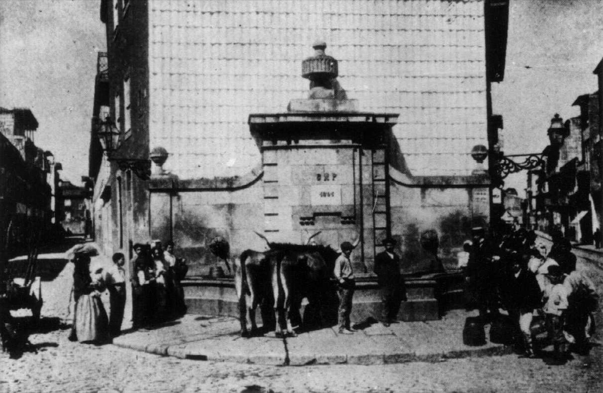 Historical photograph of the Fonte do Largo do Padrão fountain, with people and animals gathered to draw water